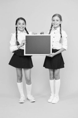 Biraz ama akıllı. Sarı arka planda tahta tutan küçük okul çocukları. Eğitim için siyah tahta olan küçük çocuklar. Okul Chalkboard ile küçük kızlar, kopya alanı