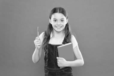 notlar yazma. çocuk günlüğü. okul kız turuncu arka plan kitap okuyun. dizüstü bilgisayar ile mutlu küçük kız. şiir ve roman. modern eğitim. edebiyat dersi. Okula geri dön. Sınavlara hazırlık