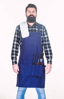 Açık havada yemek pişirme. Sakallı adam ceplerinde ızgara tutucu araçları ile apron giyiyor. Barbekü ızgara için metal eşyaları ile hipster. Mangal aşçımız. Barbekü seti kullanarak ızgarada yiyecek hazırlama