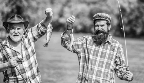 家族の時間だ釣り竿を持つ漁師。活動と趣味。友人釣りを持つ成熟した男。夏休み。幸せな陽気な人々。淡水湖池川釣り。魚を捕まえるあごひげの男性 — ストック写真