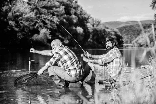 Poaching crime and fishing license. Black market caviar. Poachers fishing. Trap for fish. Men sit at riverside with fishing equipment. Illegal hunting caviar. Extracts eggs from sturgeon caught river — Stock Photo, Image