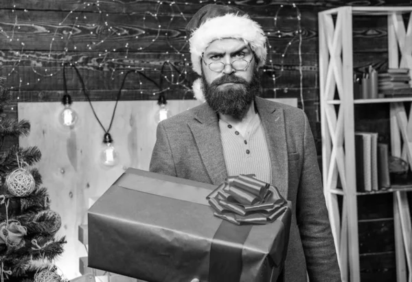サンタの宅配便。男サンタ帽子は、ギフトをお届け。広がる幸福感と喜び。眼鏡とひげを生やした男は、プレゼント ボックスを運ぶ。配信クリスマス プレゼント。配信サービス。クリスマスが来ています。ギフト配達 — ストック写真