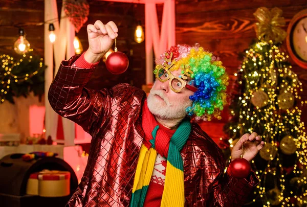 Mature man with white beard. Winter holidays. Christmas decorations home. Hocus pocus. Christmas spirit. Cheerful clown colorful hairstyle. Bearded senior man celebrate christmas. Party entertainment