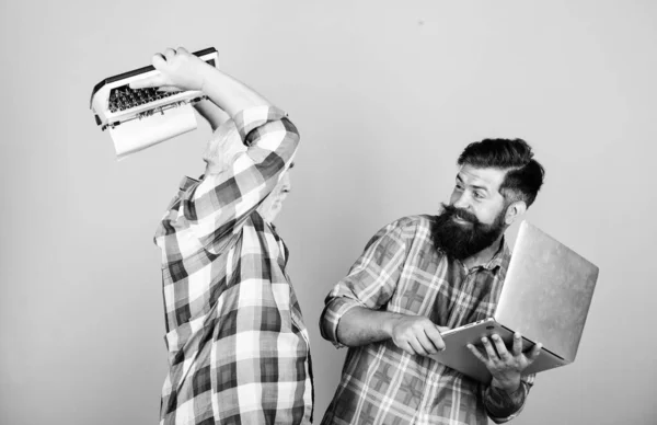 crush test. retro typewriter vs laptop. New technology. father and son. family generation. youth vs old age. business approach. technology battle. Modern life. two bearded men. Vintage typewriter