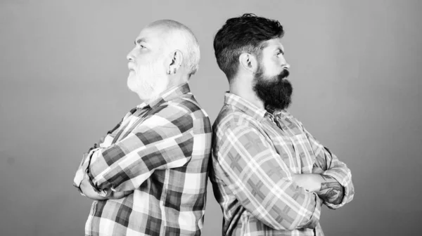 father and son family. generational conflict. barbershop and hairdresser salon. male beard care. checkered fashion. youth vs old age compare. retirement. two bearded men senior mature. relationship