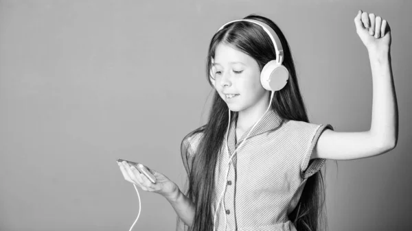 new playlist. home schooling. child study online. E learning with ebook. girl listen to music. Audio book. back to school. small girl pupil in headphones. self education. Mp3 player. copy space