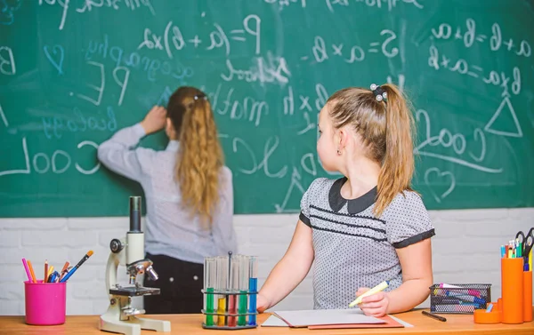 Fascinating science. Educational experiment. Girls classmates study chemistry. Microscope test tubes chemical reactions. Pupils at chalkboard chemistry lesson. Laboratory practice. Chemistry classes — Stock Photo, Image