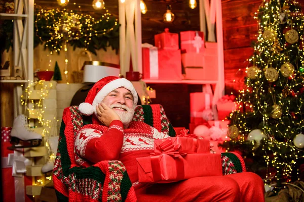 Noel Baba koltukta dinleniyor. Sakallı kıdemli Noel Baba. Gelenekler konsepti. Yaşlı büyükbaba evde. Noel Baba hakkında bir efsane. Mutlu noeller. Hediye teslimatı. Aile için hediyeler — Stok fotoğraf