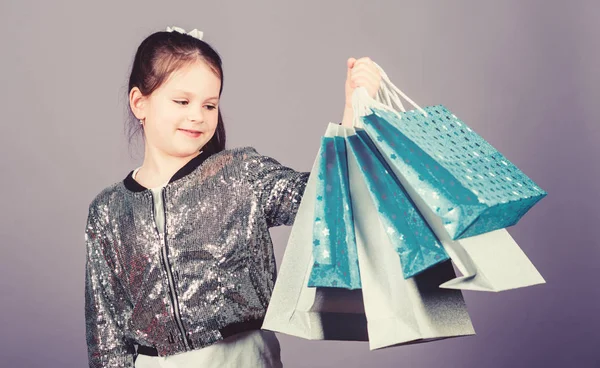 Korting voor verkoop. Dagje winkelen. Kind houden bos pakketten. Kinderen mode. Verjaardag meisje. Verrassing cadeau. Meisje met shopping tassen Violet achtergrond. Winkelen en kopen. Krijg beter op zoek. Zwarte vrijdag — Stockfoto