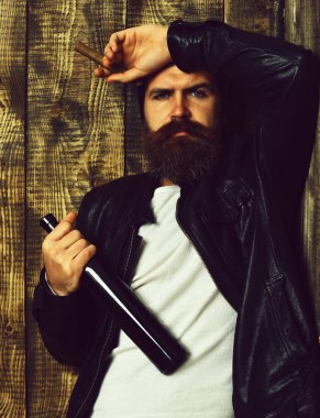 Sakallı, Kafkas hippisi elinde şişe, puro içiyor.