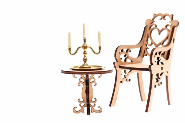 Svícen z zlato na stůl a dekorativní dřevěné židle — Stock fotografie