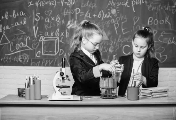 Genius dzieci pracują na własną teorię chemiczną. Podstawowa wiedza z chemii. Uczniowie cute dziewcząt używać probówek z płynami. Koncepcja eksperymentu chemicznego. Środki bezpieczeństwa zapewniające bezpieczną reakcję chemiczną — Zdjęcie stockowe