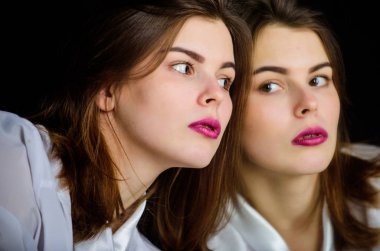 Aynaya bakan refleksli kız. Görünüm konsepti. Güzellik ve cilt bakımı. Kadın makyajı yüzü pembe dudaklar. Güzellik salonu. Makyöz. Günlük makyaj. Güzel bayan. Kadınlık