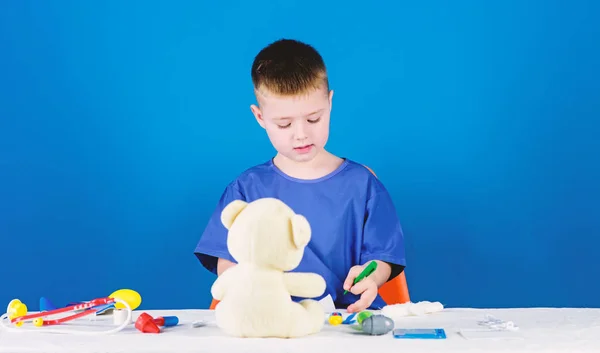 Kid little doctor busy sit table with medical tools. Medical examination. Medical procedures for teddy bear. Boy cute child future doctor career. Hospital worker. Health care. Medicine concept — Stock Photo, Image