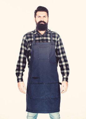 Apron giysilerini sıçramalardan koruyor. Cepleri ile pişirme önlük Master aşçı. Sakallı adam mutfak önlüklerinde yemek pişirir. Izgara aşçı beyaz izole. Uzun sakallı önlük giyen aşçı