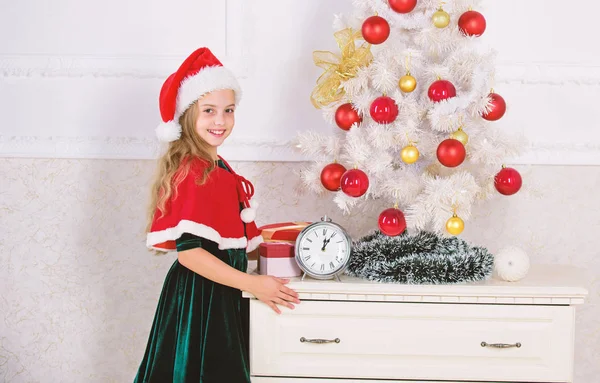 Last minute till midnight. New year countdown. Last minute new years eve plans that are actually lot of fun. Girl kid santa hat costume with clock counting time to new year. How much time before