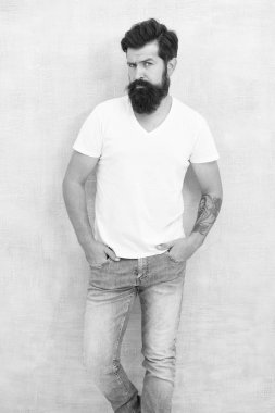 Seksi, yakışıklı. Yakışıklı hippi pantolonu. Erkek moda trendleri. Basit ve sıradan bir yaz. Acımasız maço gri arka plan. Erkek şiddeti. Sakallı adam erkeklik saçıyor. fiziksel çekicilik