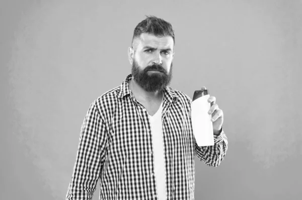 Wird es mir helfen. Guten Morgen. perfekte Hautlotion. Brutale Hipster halten Shampoo-Flasche. bärtiger Mann mit gesundem Haar. Kosmetik für Wellness-Bad. Bartpflege. männliche Schönheit. Selbstreinigung — Stockfoto