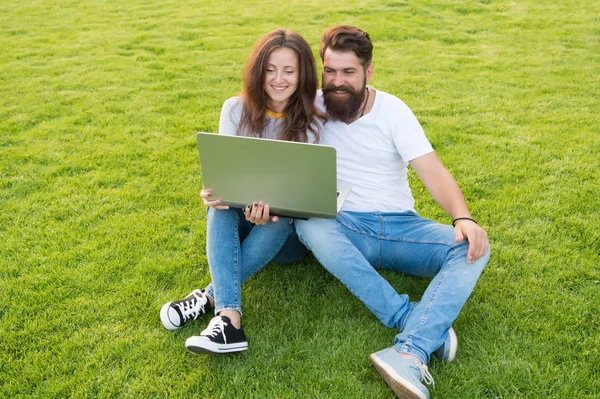 Online underhållningsplattform. Prenumerera på streamingtjänster online. Modern teknik. Par sitta gräsmatta med anteckningsbok. Surfar på internet. Tillbringa fritid dator. Mannen flicka tittar på skärmen. Onlineliv — Stockfoto