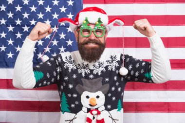 Gelmiş geçmiş en iyi parti. Amerika 'da Noel. Amerikan bayrağı geçmişinde Noel Baba. Sakallı Amerikalı adam yeni yılı kutluyor. Ulusal Amerikan bayrağı. Vatansever hipster kış tatilini kutluyor. Tüm Amerikan Xmas partileri