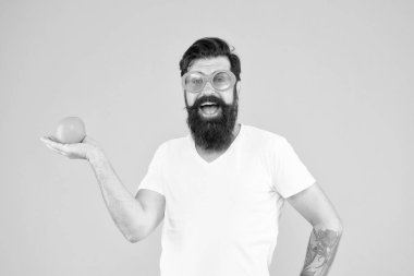 Hayatın boyunca meyve gibi görünüyorsun. Sarı arka planda portakal meyvesi tutan sakallı adam. Sağlıklı meyve atıştırmalık ile Hipster. Beyaz adam organik vitamin meyve seçimi