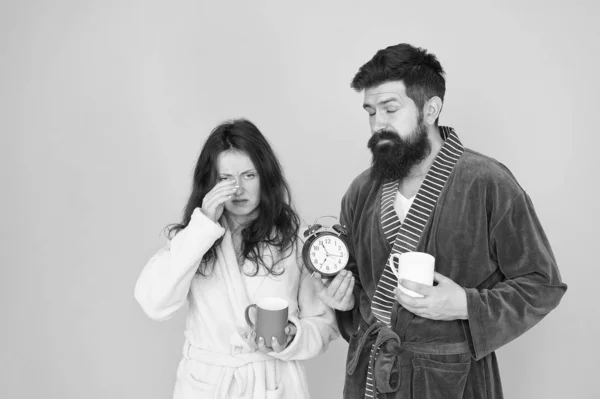 hard morning. Sleepy people. morning couple drink coffee. bearded man and girl coffee cup. wake up time. family life routine. couple in love alarm clock. tea time at home. morning tastes better