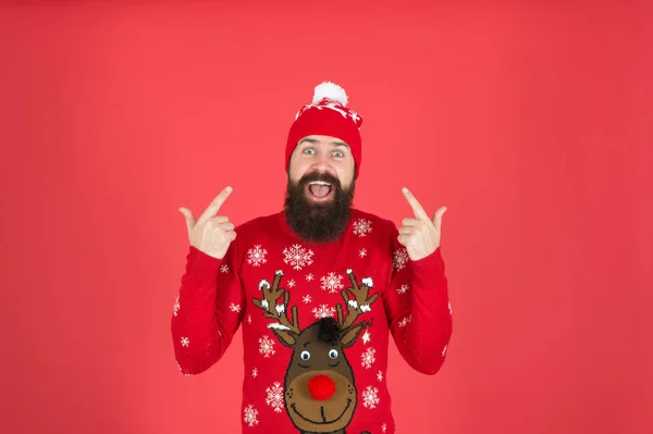 Hipster cheerful bearded man wear winter sweater and hat. Happy new year. Join holiday party craze and host ugly christmas sweater party. Feeling awesome. Buy festive clothing. Sweater with deer — Stock Photo, Image