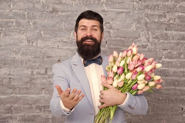 Macho auf dem Weg zum romantischen Date. Tulpen für Liebhaber. Romantisches Geschenk. Mann gepflegte Smoking-Fliege hält Blumenstrauß. Wie man Gentleman wird. Leitfaden für den modernen Menschen. Romantiker Mann mit Blumen — Stockfoto