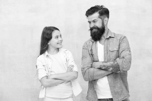 Be happy and smile. Happy family. Happy father and little daughter keeping arms crossed on grey background. Bearded man and small child happy smiling