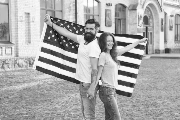 National holiday. Bearded hipster and girl celebrating. 4th of July. American patriotic people. American citizens couple USA flag outdoors. Patriotic spirit. Independence day. American tradition