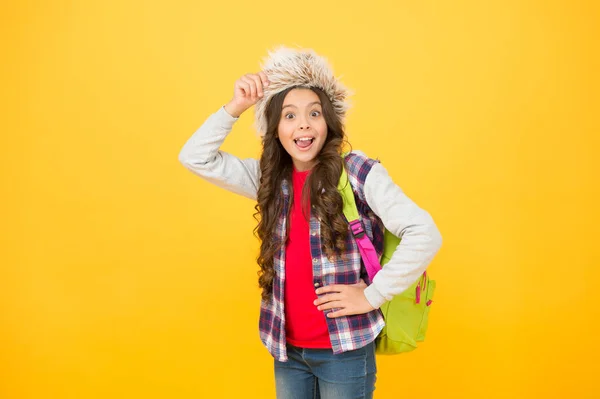 Dziewczynka nosi kapelusz z klapkami na uszy. Zimowe wakacje. Przedstaw cele edukacyjne refleksje na semestr. Zimowe imprezy w szkole. Zimowa rozrywka i atrakcje. Dziecko uczennica miękki kapelusz cieszyć sezon — Zdjęcie stockowe