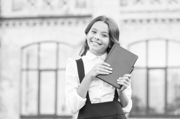 Witamy z powrotem w szkole. Szczęśliwa dziewczynka idzie ze szkolnej biblioteki. Słodki uśmiech dziecka w szkole podstawowej z książką w rękach. Przygotuj się do szkoły. 1 września. Dzień wiedzy. Wczesne kształcenie — Zdjęcie stockowe