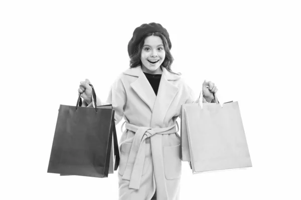 Οι βαλίτσες είναι γεμάτες. Ευτυχισμένος αγοραστής κρατάει τσάντες για ψώνια. Ένα μικρό χαμόγελο με χάρτινες σακούλες. Το μικρό κορίτσι απολαμβάνει εποχιακές εκπτώσεις. Μεταφορά αγορών διακοπών σε πολύχρωμες τσάντες. Φθινοπωρινή πώληση — Φωτογραφία Αρχείου