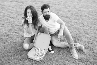 Basit mutluluk. Hile yemeği. Yeşil çimenlikte dinlendirici pizza yiyen çift. Fast food teslimatı. Sakallı adam ve kız arkadaşı peynirli pizzanın tadını çıkarırlar. Aşık çift pizza ile açık havada kalma. Aç insanlar