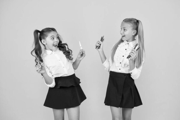 Веселое обучение для детей. Маленькие дети улыбаются с творческими инструментами на желтом фоне. Счастливые маленькие дети с ножницами и маркерами. Искусство и ремесла для маленьких детей
