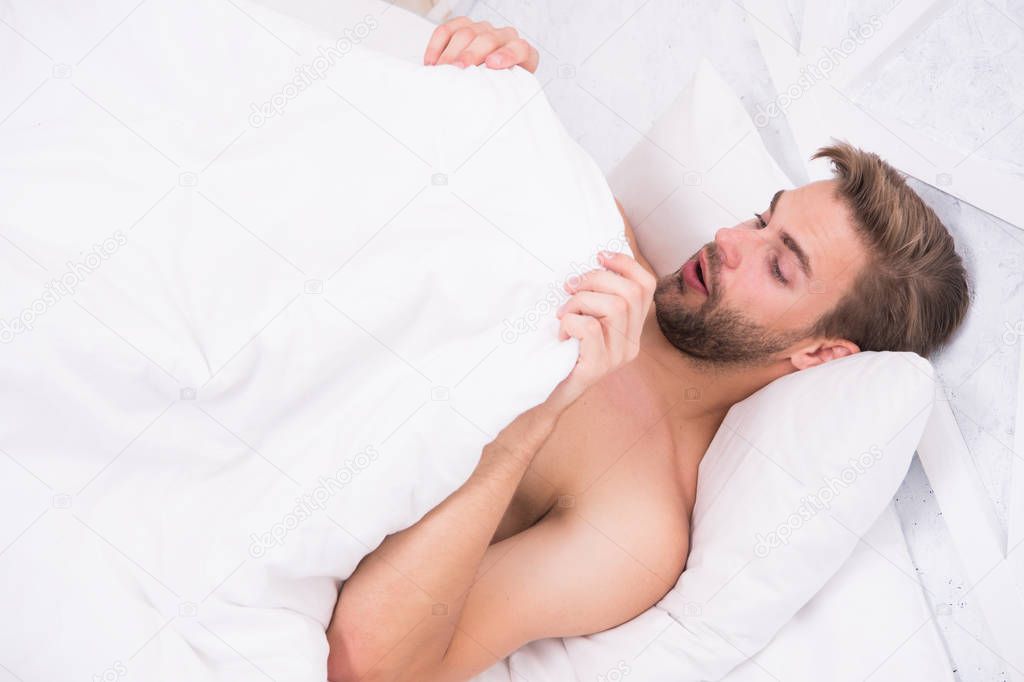 Man looking under blanket. Morning wood formally known nocturnal penile tumescence common occurrence. Male reproductive system. Why men get morning erections. Normal erections occur. Guy relax in bed