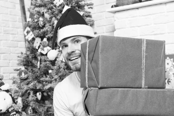 Macho in red hat smile with wrapped presents — Stock Photo, Image