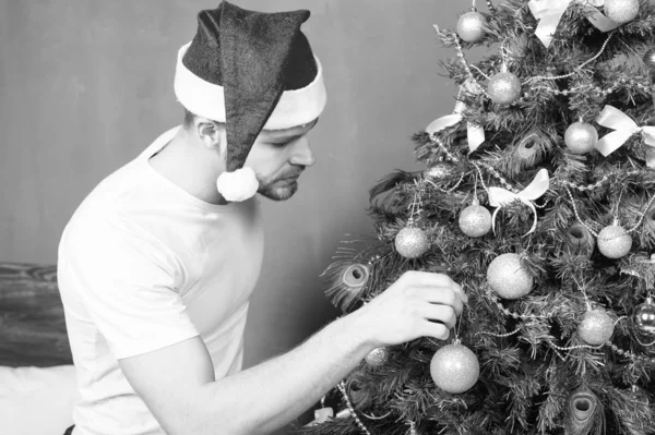 Santa man versieren kerstboom met gouden bauble — Stockfoto