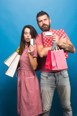 Maço adam alışveriş torbaları tutar. Sakal ve Bayan adam