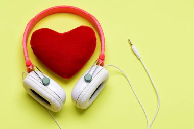 Beyaz ve kırmızı renkli yumuşak oyuncak kalp ile kulaklıklar