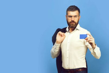 Beyaz gömlekli sakallı adam mavi kartvizit tutar