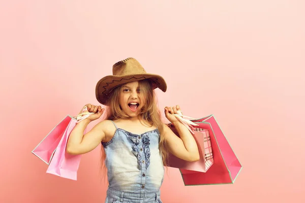 Dívka s růžový nákupní tašky. Móda a shopaholism koncept — Stock fotografie