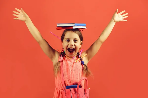 Chica sostiene los libros rojos y azules en las manos —  Fotos de Stock