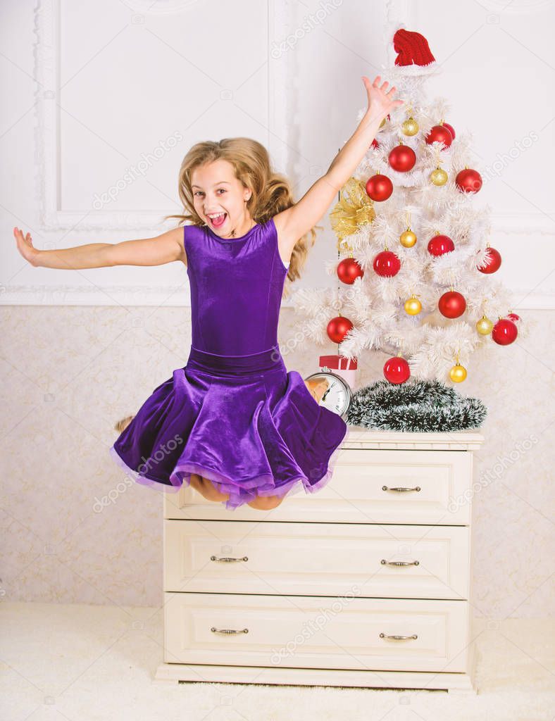 Child emotional cant stop her feelings. Girl in dress jumping. It is christmas. Day we have waited for all year finally here. Girl excited about christmas jump mid air. Celebrate christmas concept