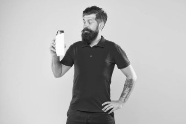 Zorlu saçlar için uzman bakımı. Şampuanlı plastik kap. Saç tipi için şampuan. Saçı daha güçlü yap. Adam yakışıklı sakallı hipster şişe şampuan duş jeli tutun. Erkekler için şampuan kremi