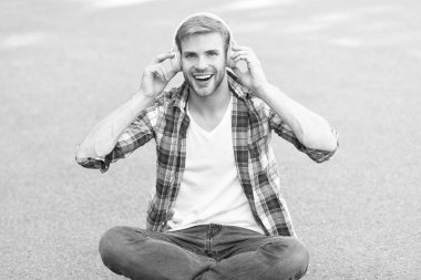 gerçek mutluluk. serbest zaman. online eğitim. müzik dinleyin. ebook kavramı. adam damalı gömlek. öğrenci rahatlayın kulaklık kullanın. mutlu adam açık. adam yere otur. kulaklıkta kaygısız öğrenci