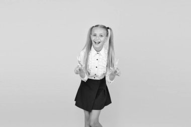 Eğlenerek öğreniyorum. Mutlu küçük okul çocuğu sarı arka planda güvenli makas kullanmayı öğreniyor. Küçük kız okulda makasla kesmeyi öğreniyor. Makas öğrenerek motor becerileri geliştiriyorum.