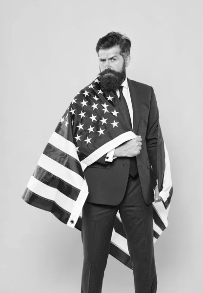 Nationell stolthet. Skäggiga mannen bär nationella flaggan i USA på Formalwear. Trygg affärsman firar nationell helgdag den 4 juli. Nationell Business Manager på gul bakgrund — Stockfoto