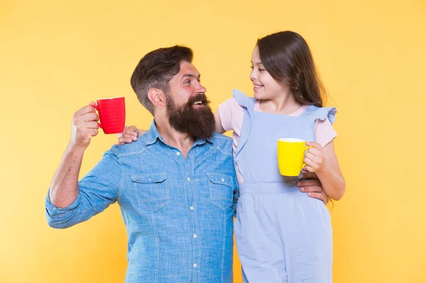 Bearded man and happy girl holding mugs. Father and daughter hot drink. Drink water. Drink fresh juice. Breakfast concept. Good morning. Having coffee together. Healthy lifestyle. Family drinking tea — Stock Photo, Image