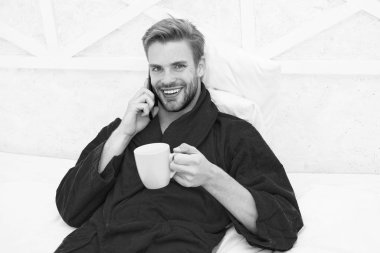 Bunu duyduğuma sevindim. Gezici konuşma. Cep telefonu. İletişim cep telefonu. İyi haber konsepti. İyi sabahlar. Hipster adam pijama bornoz serbest çalışan evde dinleniyor. Uzak çalışma konsepti